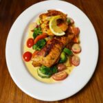 Seafood in a cream sauce with tomatoes, broccoli and zucchini.